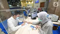 Nasabah Unit Usaha Syariah (UUS) PT Bank Tabungan Negara (Persero) Tbk. tengah melakukan transaksi di kantor BTN Syariah di Jakarta, Rabu (06/04/2021). BTN Syariah tetap mencatatkan pertumbuhan kinerja mencapai double digit kendati berada di masa pandemi. (Liputan6.com/Pool/BTN)