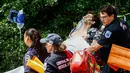Petugas mengevakuasi seorang pemuda yang terluka parah setelah menjadi korban ledakan di Central Park, New York, Minggu (3/7). Sebagian Central Park pun langsung ditutup sementara personel NYPD melakukan penyelidikan. (Kena Betancur/AFP)