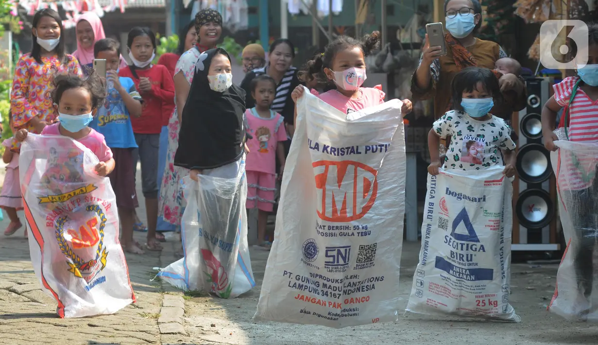 Anak-anak saat mengikuti lomba balap karung peringatan HUT Kemerdekaan ke-76 RI di Benda Baru, Pamulang, Tangsel, Selasa (17/8/2021). Di sejumlah kawasan pinggiran Jabotabek warga tetap melaksanakan peringatan HUT kemerdekaaan RI walau masih dalam status PPKM Level 4. (merdeka.com/Arie Basuki)