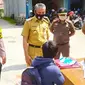 Petugas memberikan denda kepada warga Pekanbaru yang kedapatan tidak memakai masker. (Liputan6.com/M Syukur)