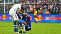 Bek Persib Bandung, Bojan Malisic membantu gelandang Arema, Makan Konate untuk bangkit usai pertandingan di Stadion Kanjuruhan, Kab. Malang, Jumat (22/2/2019). (Bola.com/Iwan Setiawan)