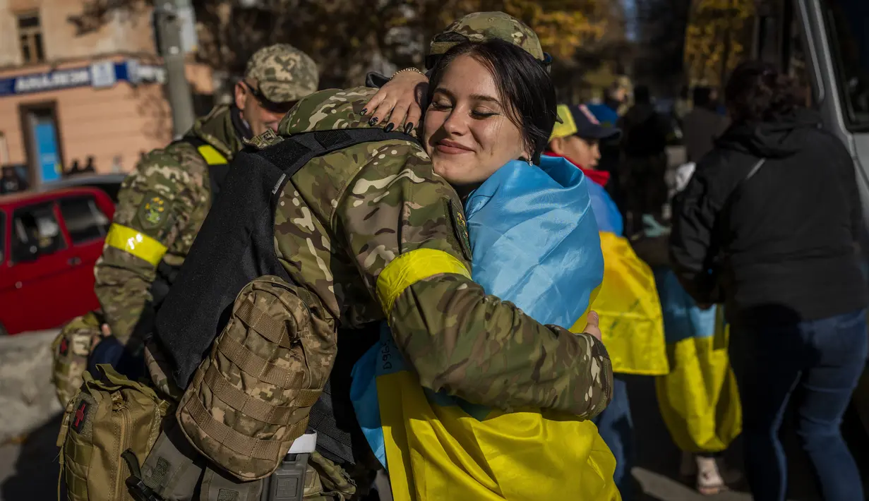 Seorang warga Kherson memeluk anggota pasukan pertahanan Ukraina di Kherson, Ukraina selatan, Senin (14/11/2022). Perebutan kembali Kherson adalah salah satu keberhasilan terbesar Ukraina dalam hampir sembilan bulan sejak invasi Moskow. (AP Photo/Bernat Armangue)