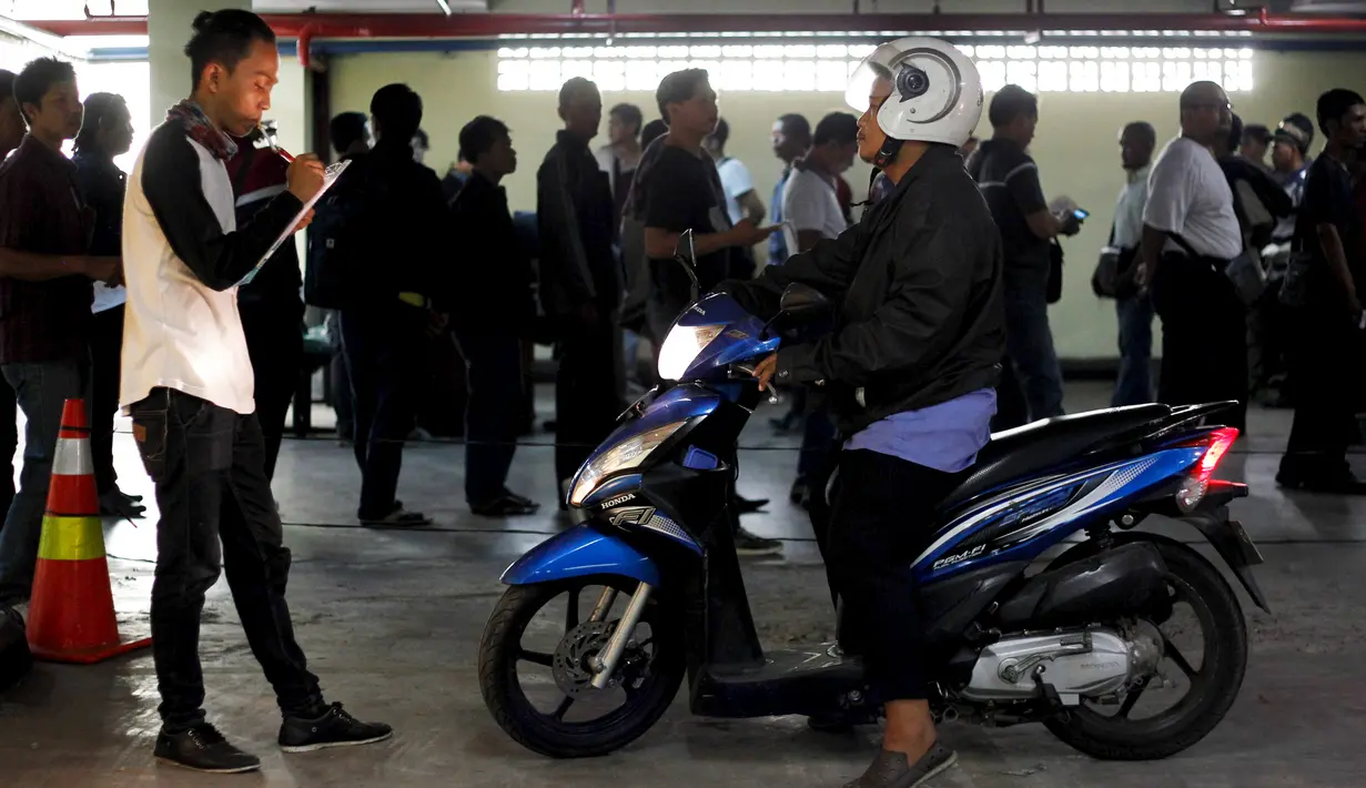 Petugas melakukan pengecekan motor pada calon pengemudi ojek saat mengikuti tes di Jakarta, 9 Januari 2016. Semakin berkembang dan diterima layanan Ojek Online, semakin banyak juga calon pengemudi yang melamar untuk menjadi driver (REUTERS/Garry Lotulung)