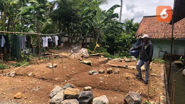 seorang warga saat menunjukan pembangunan pondasi untuk hunian tetap yang diberhentikan bagi penyintas bencana retakan tanah di Kampung Jati, Desa Mekarsari, Kecamatan Nyalindung, Kabupaten Sukabumi. (Liputan6.com/Fira Syahrin).