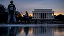 Lincoln Memorial terlihat saat bersaudara Jacek Zavora (21) dan Zach Zavora (10) bermain hoki di Reflecting Pool yang membeku, National Mall, Washington, Amerika Serikat, 26 Desember 2022. (AP Photo/Andrew Harnik)
