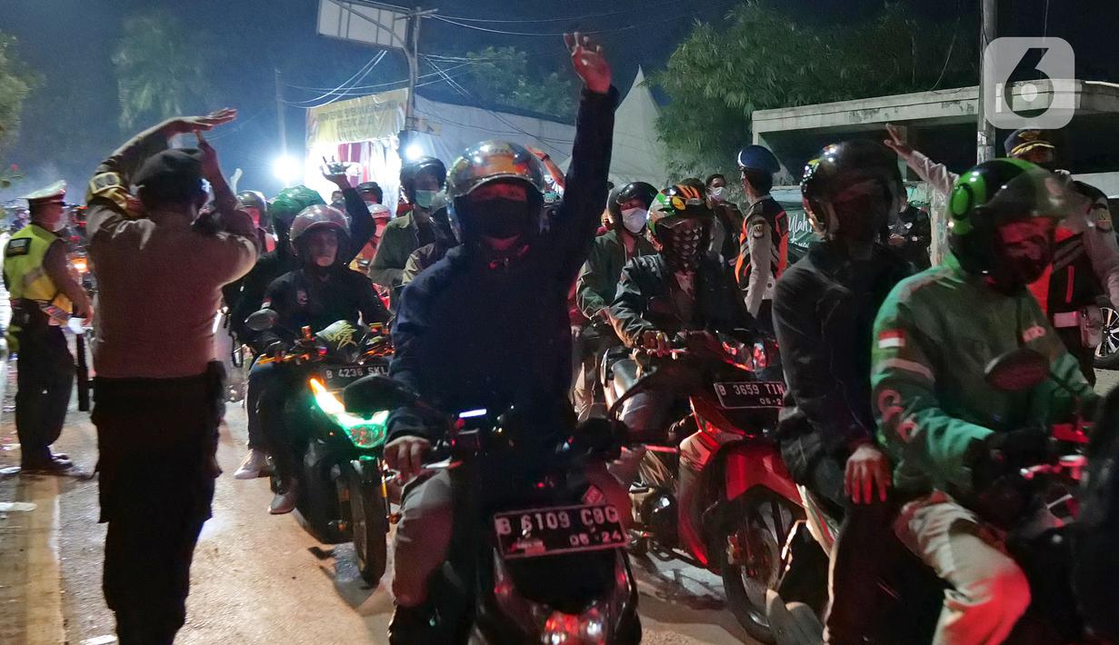 Pemudik motor melintas di posko penyekatan mudik di Kedungwaringin, Kabupaten Bekasi, Jawa Barat, Selasa (11/5/2021) dini hari. Polisi kembali memberlakukan diskresi terhadap pemudik motor yang melintasi jalur Pantura antara Kabupaten Bekasi dan Kabupaten Karawang. (Liputan6.com/Herman Zakharia)