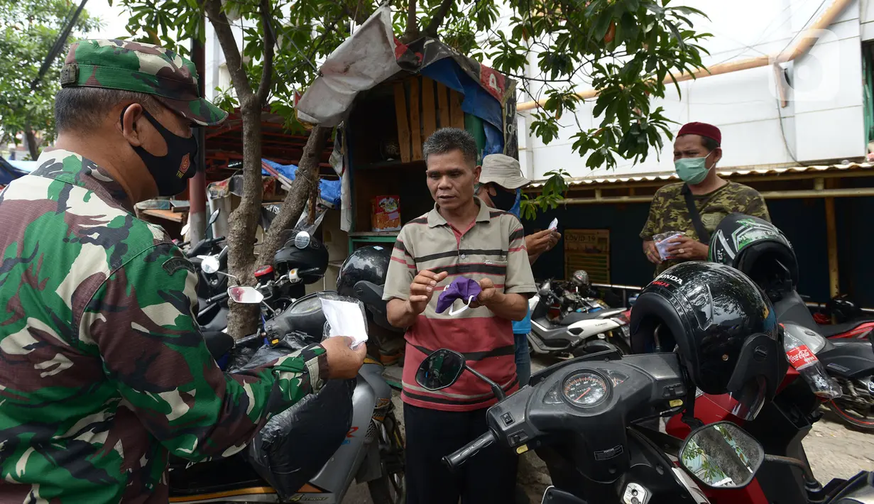Anggota TNI membagikan masker kepada warga di Pasar Jatinegara, Kamis (10/9/2020). Petugas gabungan terus melakukan himbauan untuk memakai masker dan membagikan masker di pasar tersebut. (merdeka.com/Imam Buhori)