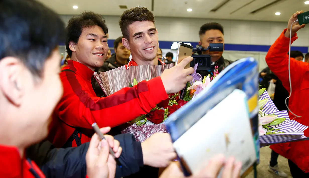 Gelandang asal Brasil, Oscar berfoto bersama penggemarnya di Bandara Internasional Shanghai Pudong di Shanghai, Senin (2/1). Oscar setuju bergabung bersama klub China Shanghai SIPG dengan tawaran gaji sekitar Rp 6,6 miliar per pekan. (REUTERS/Aly Song)
