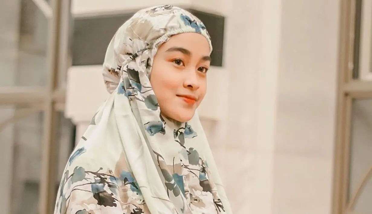 Selain menginspirasi soal makeup, Diniyaan juga memberikan inspirasi dalam hal gaya hijab. Memutuskan pakai hijab di usia muda, tak sedikit yang memuji selebgram asal Bandung ini. Punya wajah cantik dan kalem, beauty vlogger berusia 19 tahun ini bikin adem saat mengenakan mukena. (Liputan6.com/IG/@diniyaan)