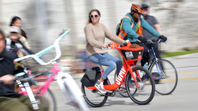 Seorang wanita mengendarai sepeda di jalan bebas kendaraan bermotor pada acara CicLAvia di Culver City, Los Angeles, Minggu (3/3). Selain dihadiri oleh pesepeda, CicLAvia atau car free day ini juga akan diramaikan oleh pejalan kaki. (Chris Delmas/AFP)