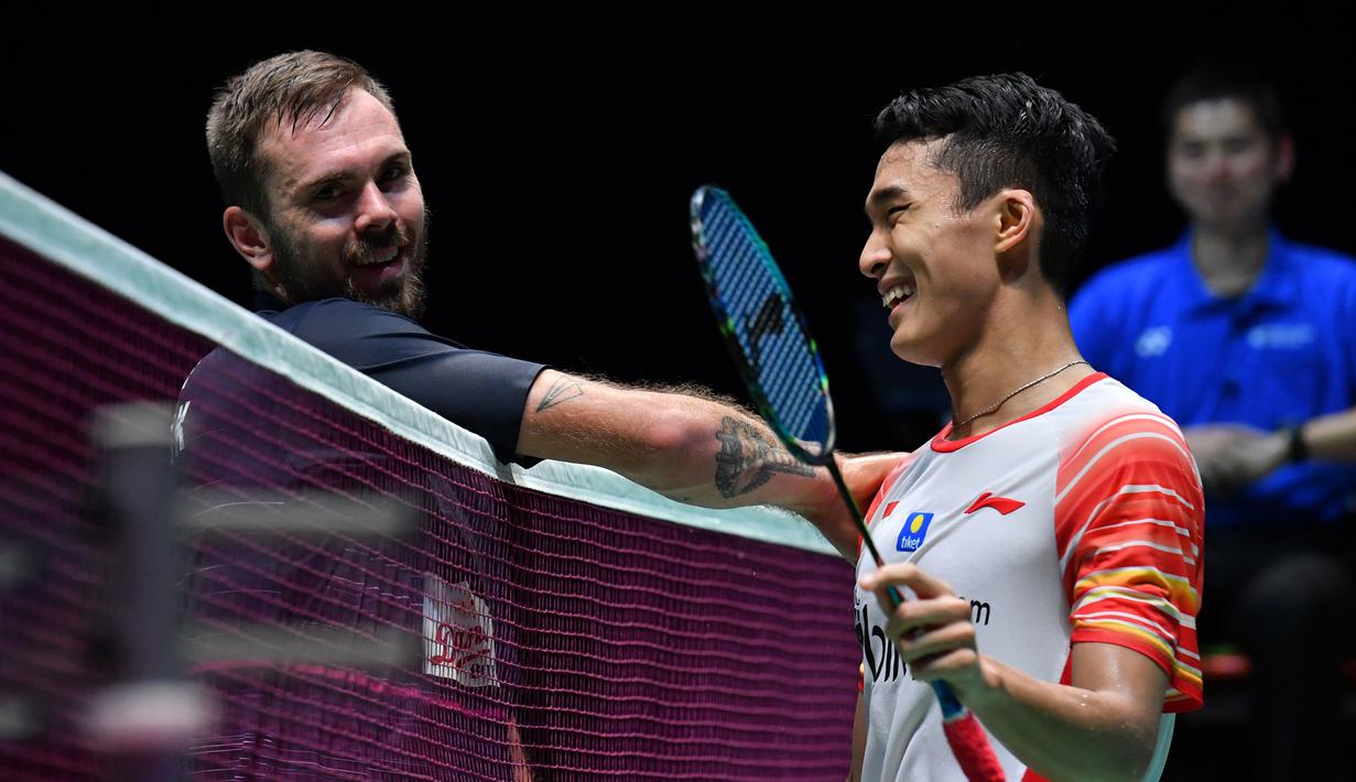Tunggal putra Indonesia, Jonatan Christie tersenyum saat bersalaman dengan Jan O Jorgensen  dari Denmark usai bertanding dalam babak semifinal Jepang Terbuka 2019  di Tokyo (27/7/2019). Jonatan Christie akan melawan Kento Momota dari Jepang di babak final. (AFP Photo/Toshifumi Kitamura)