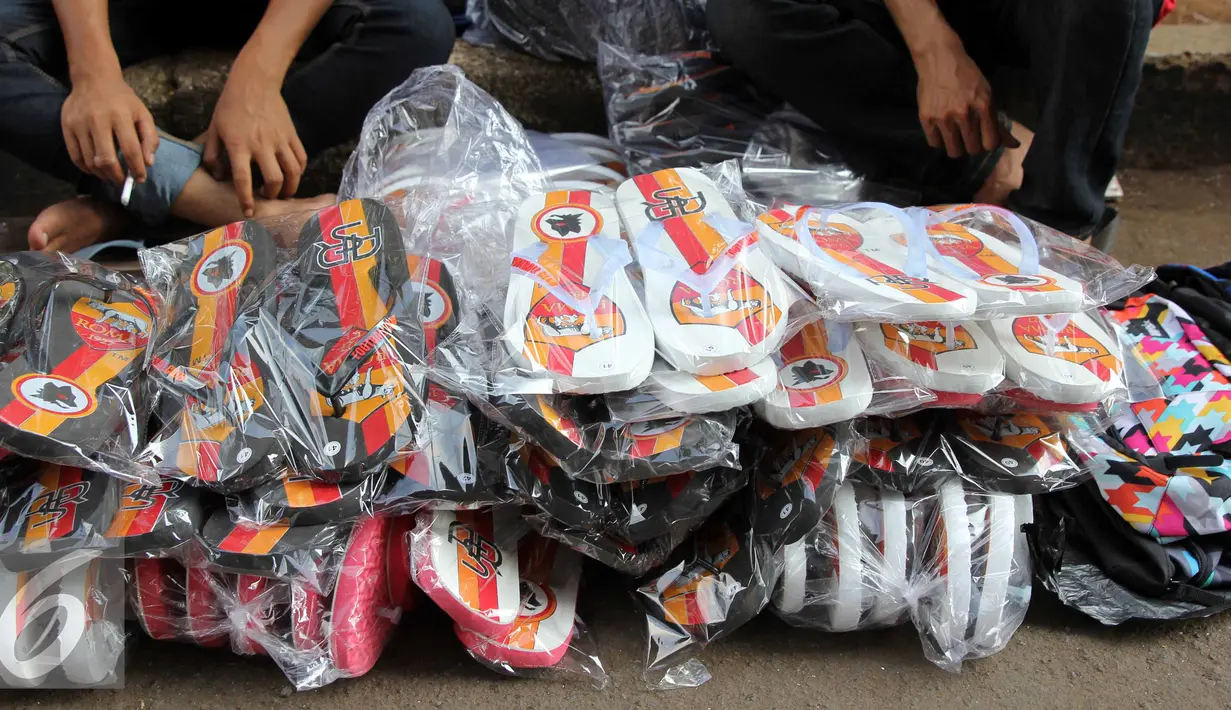 Penampakan sandal bercorak tim Liga Italia, AS ROMA di Stadion Utama Gelora Bung Karno, Jakarta, Sabtu (25/7/2015). Para pedagang mengaku dagangan mereka laris jelang pertandingan AS Roma. (Liputan6.com/Helmi Afandi)