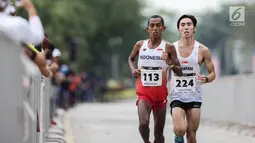 Pelari Indonesia Agus Prayogo saat memasuki garis finish trek maraton SEA Games XXIX di Putra Jaya, Kuala Lumpur, Malaysia, Sabtu (19/8). Agus mencatatkan waktu 2 jam 31 menit 19 detik. (Liputan6.com/Faizal Fanani)