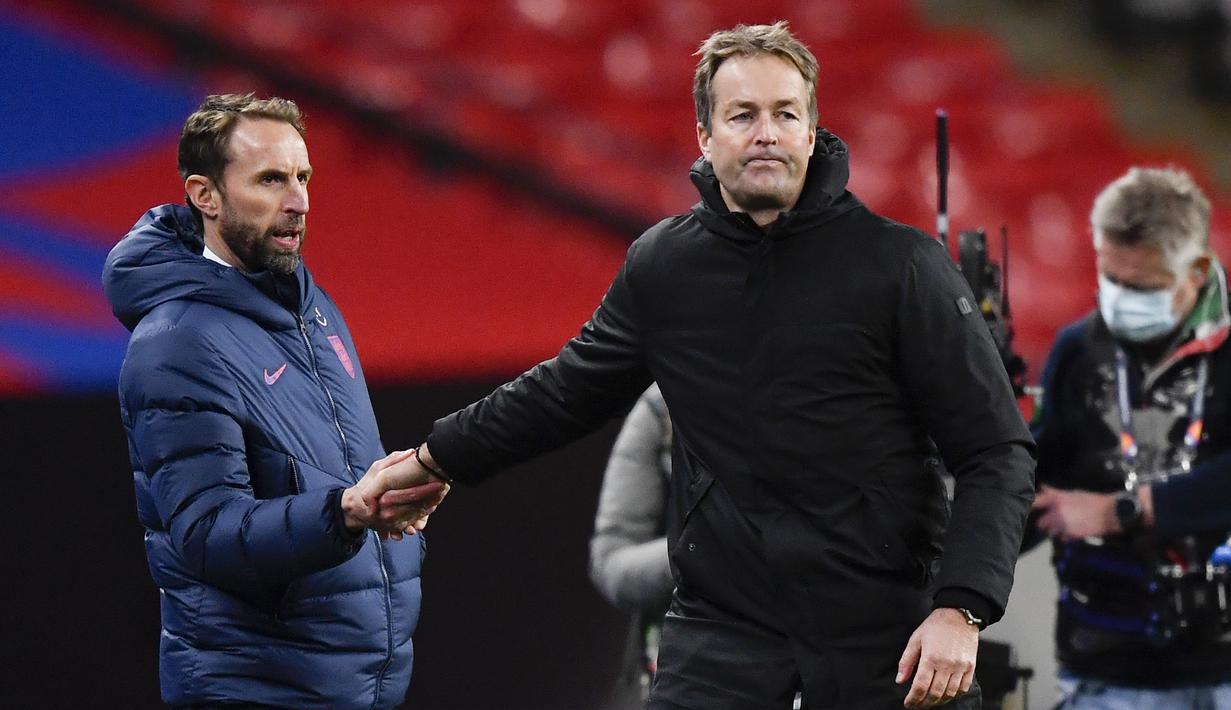 Manajer Inggris Gareth Southgate (kiri) berjabat tangan dengan Manajer Denmark Kasper Hjulmand usai pertandingan UEFA Nations League di Stadion Wembley, London, Inggris, Rabu (14/10/2020). Denmark menang 1-0. (Toby Melville/Pool via AP)