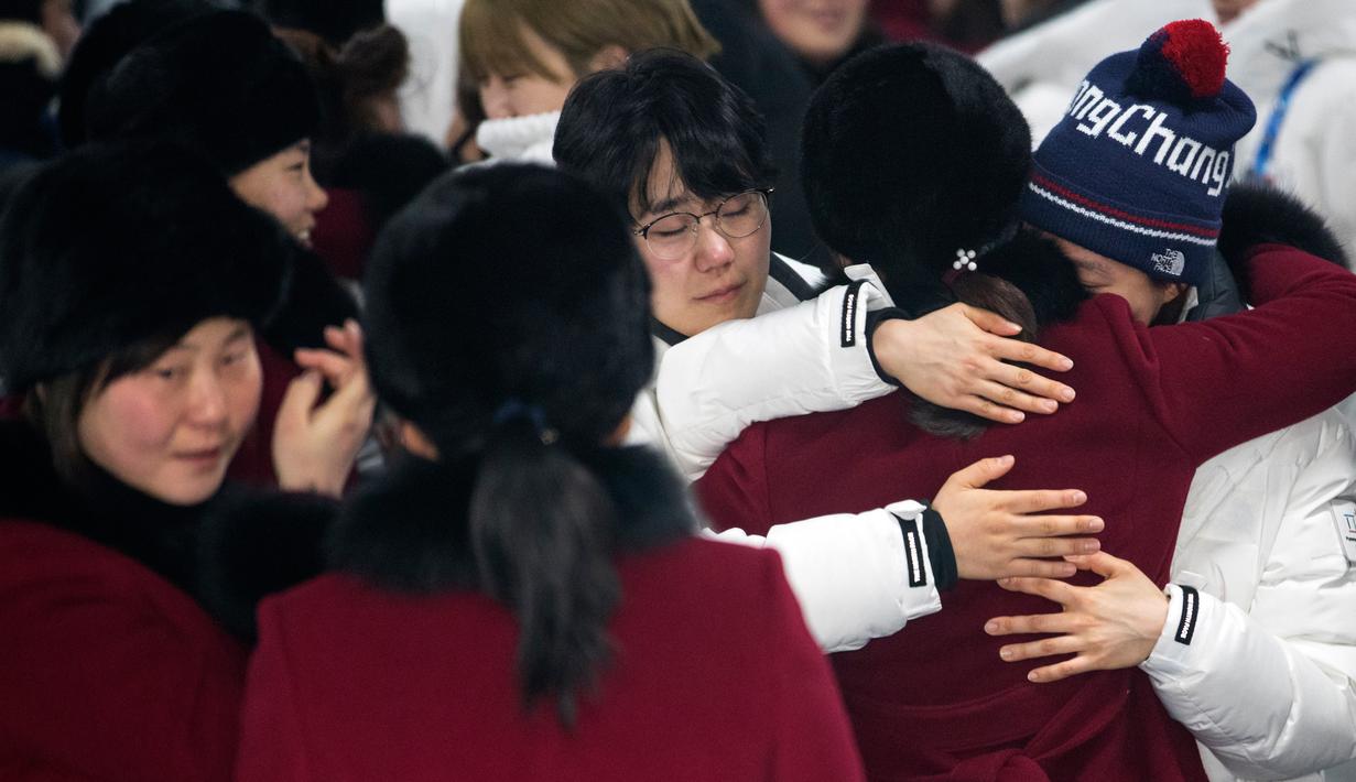 Pemain tim hoki wanita Korea Utara memeluk rekannya asal Korea Selatan saat akan kembali ke negaranya usai mengikuti Olimpiade Pyeongchang di Olympic Village, Gangneung, Korea Selatan, Senin (26/2). (Yun Dong-jin/Yonhap via AP)