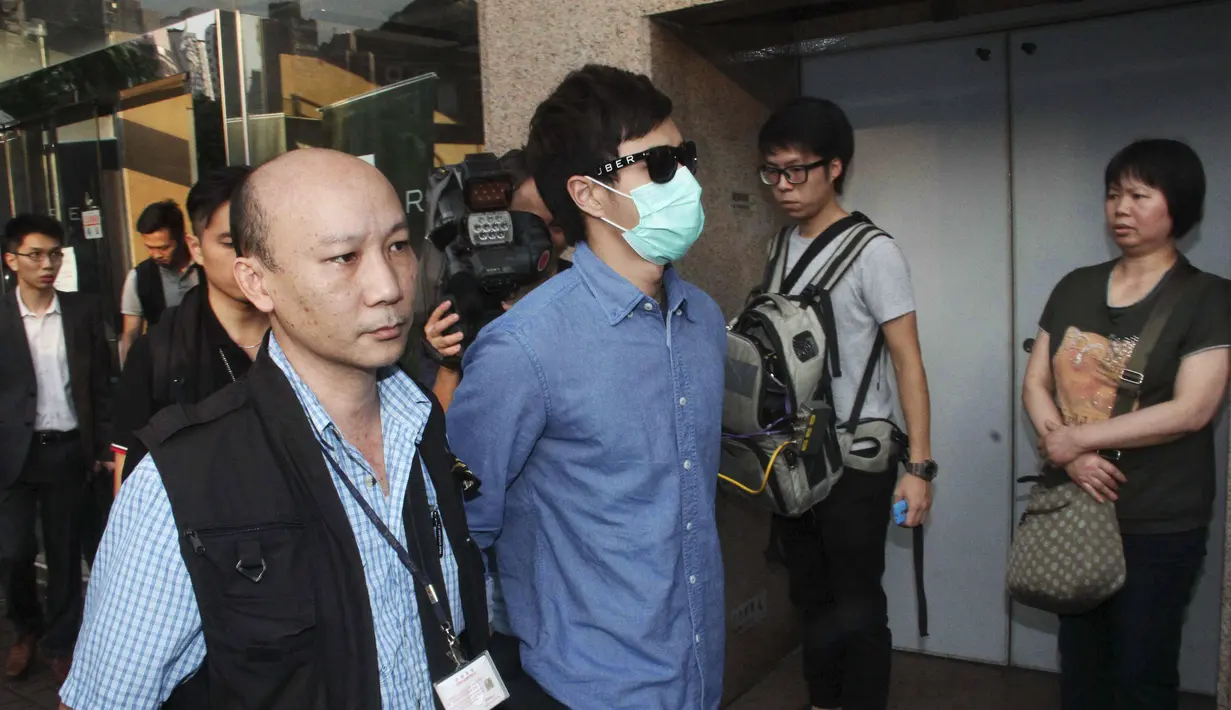 Polisi Hong Kong mengamankan seorang staff saat razia di kantor Uber Inc, Selasa (11/8/2015). Dalam razia ini polisi mengamankan 5 orang yang tertangkap basah memberikan jasa pelayanan sebagai sopir taxi dengan kendaraan ilegal. (REUTERS/Apple Daily)