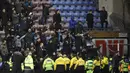 Pendukung Manchester City bereaksi setelah tim kesayangnya dikalahkan Wigan Athletic pada babak kelima Piala FA di Stadion DW, Senin (19/2). Suporter Manchester City melemparkan berbagai benda, termasuk papan iklan, ke arah lapangan. (Oli SCARFF/AFP)