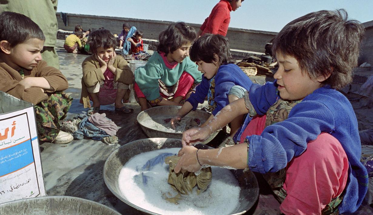Anak-anak yatim piatu mencuci pakaian di atap panti asuhan terakhir yang tersisa di Kabul, Afghanistan, 26 Oktober 1996. Milisi Taliban melarang perempuan bekerja dan berhenti mendanai panti asuhan. (SAEED KHAN/AFP)