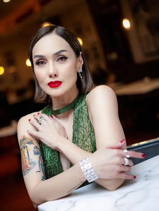 Sara terlihat mengenakan kalung kain hijau yang serasi dengan dress. Dipadukan heels transparannya. [@sarawijayanto]