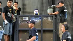 Sejumlah kru tampak menumpahkan semen ke tubuh Demian, Jakarta, Jumat (22/5/2015). Tampak Demian mengenakan masker saat proses penimbunan dirinya. (Liputan6.com/Panji Diksana) 