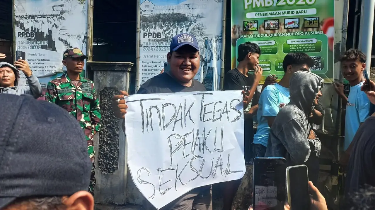 Warga mengecam perbuatan bejat pelaku dengan membawa poster di depan Ponpes Ndolo Pati.