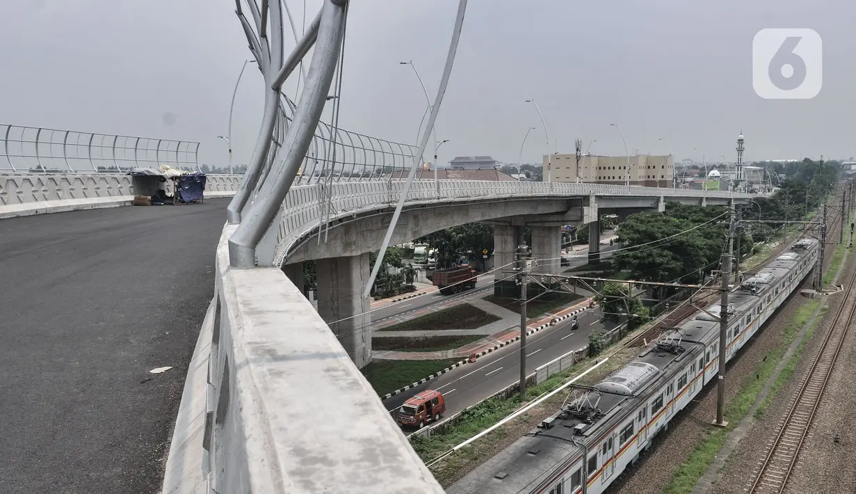 Rangkaian kereta saat melintas di bawah Flyover Cakung, Jakarta, Selasa (16/3/2021).  Progres pembangunan flyover yang menghubungkan kawasan Duren Sawit dengan Cakung tersebut saat ini telah mencapai 96,44 persen. (merdeka.com/Iqbal S. Nugroho)