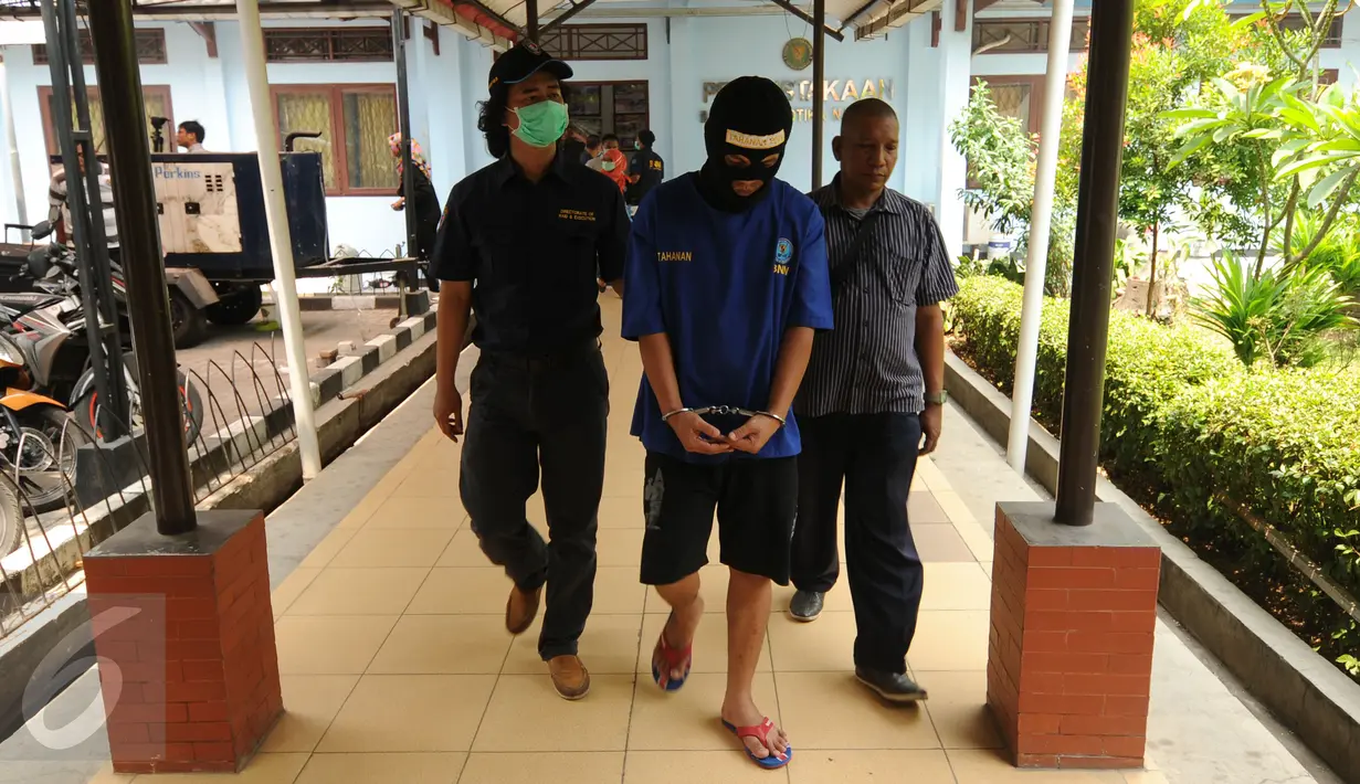 Petugas BNN menggiring salah satu tersangka pengedar narkotika jenis sabu di Gedung BNN Jakarta, Kamis (29/10/2015). Sabu seberat 22,4 kg dimusnahkan BNN dihadapan sejumlah saksi dan tersangka. (Liputan6.com/Helmi Fithriansyah)