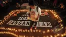 Seorang aktivis berdiri diantara ribuan lilin yang menyala dalam aksi damai di depan Istana Merdeka, Jakarta, Minggu (26/4/2015). Aksi tersebut meminta eksekusi atas Mary Jane dibatalkan. (Liputan6.com/Faial Fanani)