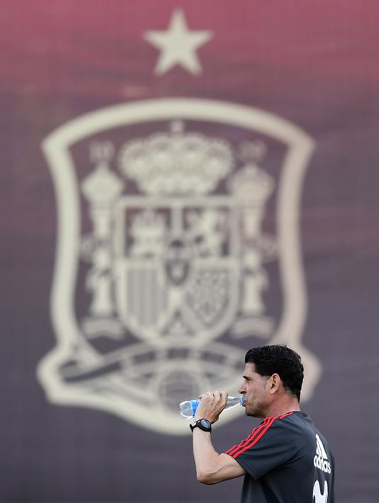Pelatih baru Spanyol, Fernando Hierro, melepas dahaga saat latihan perdananya di Krasnodar Academy, Krasnodar, Selasa (13/6/2018). Legenda Real Madrid ini ditunjuk menggantikan Julen Lopetegui. (AFP/Pierre-Philippe Marcou)