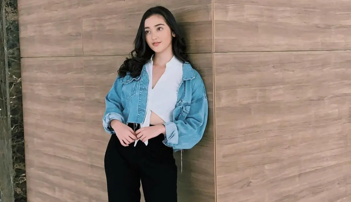 Memadukan busana putih dengan jaket jeans memang tidak pernah salah dan membuat mati gaya. Wanita 22 tahun ini juga memilih makeup natural serta rambut hitam yang dibiarkan terurai. (Liputan6.com/IG/@rantymaria)