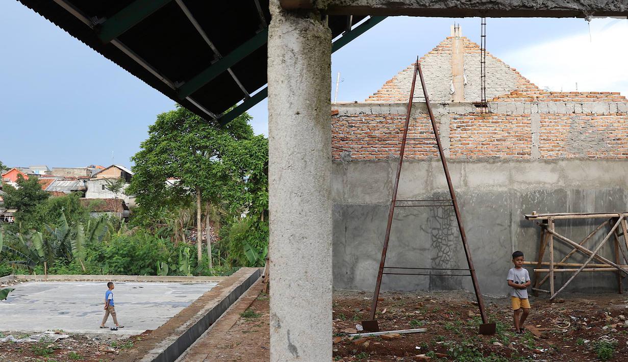 Anak-anak bermain di RPTRA Pelangi Cipedak yang pembangunannya terhenti di Jakarta, Senin (18/3). Terhentinya pembangunan RPTRA yang telah tiga kali mangkrak dikeluhkan warga karena molor dari target yang ditentukan. (Liputan6.com/Immanuel Antonius)