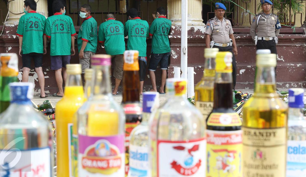 Petugas merilis tersangka dan barang bukti di Polsek Metro Palmerah, Jakarta, (22/6). Jelang Idul Fitri 1437 H, Sat Resnarkoba Polres Jakarta Barat musnahkan 10.150 botol miras, 3.597 gram shabu, dan 104 butir pil ekstasi. (Liputan6.com/Immanuel Antonius)