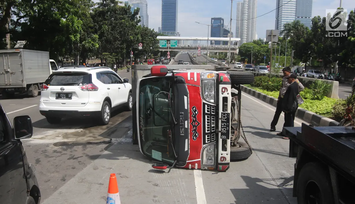 Sebuah mobil boks terguling di Jalan Casablanca, Jakarta, Rabu (27/6). Mobil bernomor polisi B 9515 FCC dikemudikan oleh Sumarno. (Liputan6.com/Arya Manggala)