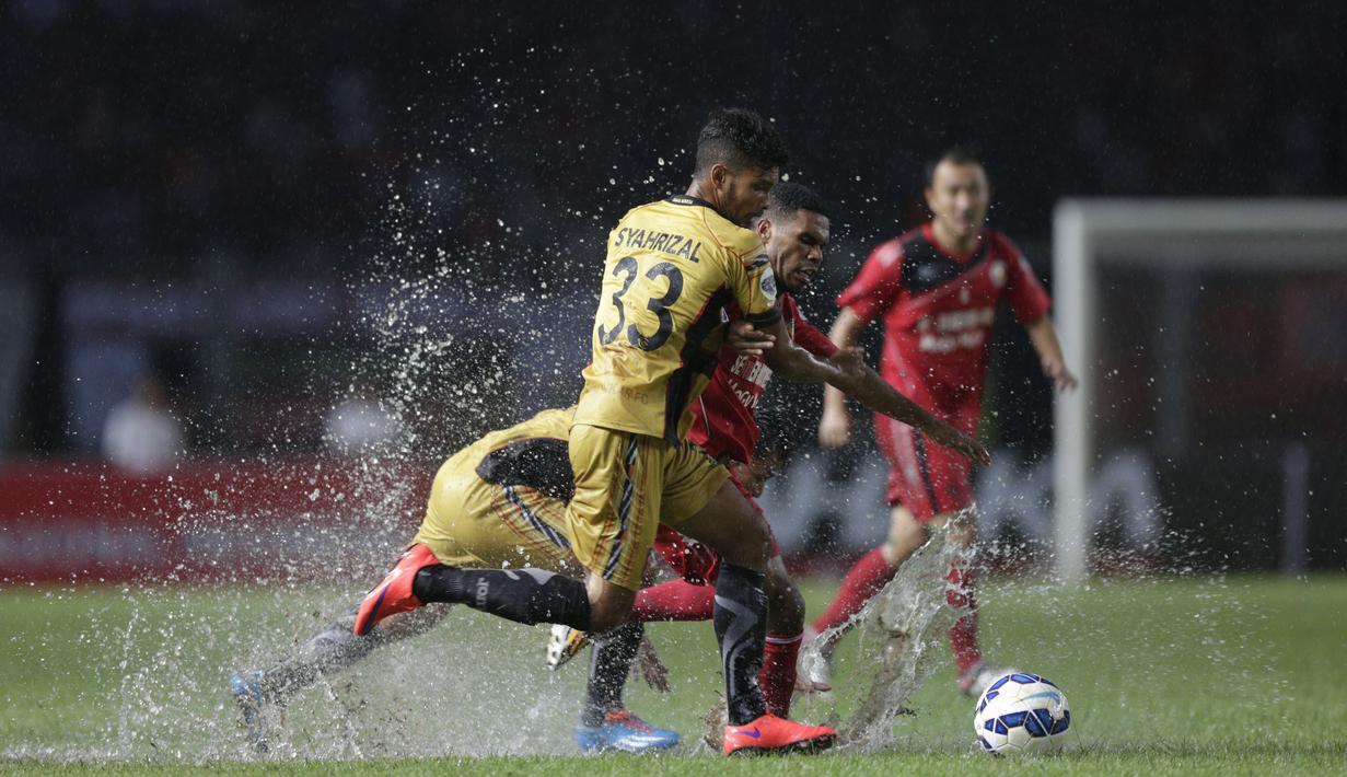 Kondisi lapangan Stadion Utama Gelora Bung Karno yang tergenang air selepas hujan lebat membuat pemain Semen Padang dan Mitra Kukar sulit mengontrol bola dalam final Piala Jenderal Sudirman, Minggu (24/1/2016). (Bola.com/Vitalis Yogi Trisna)