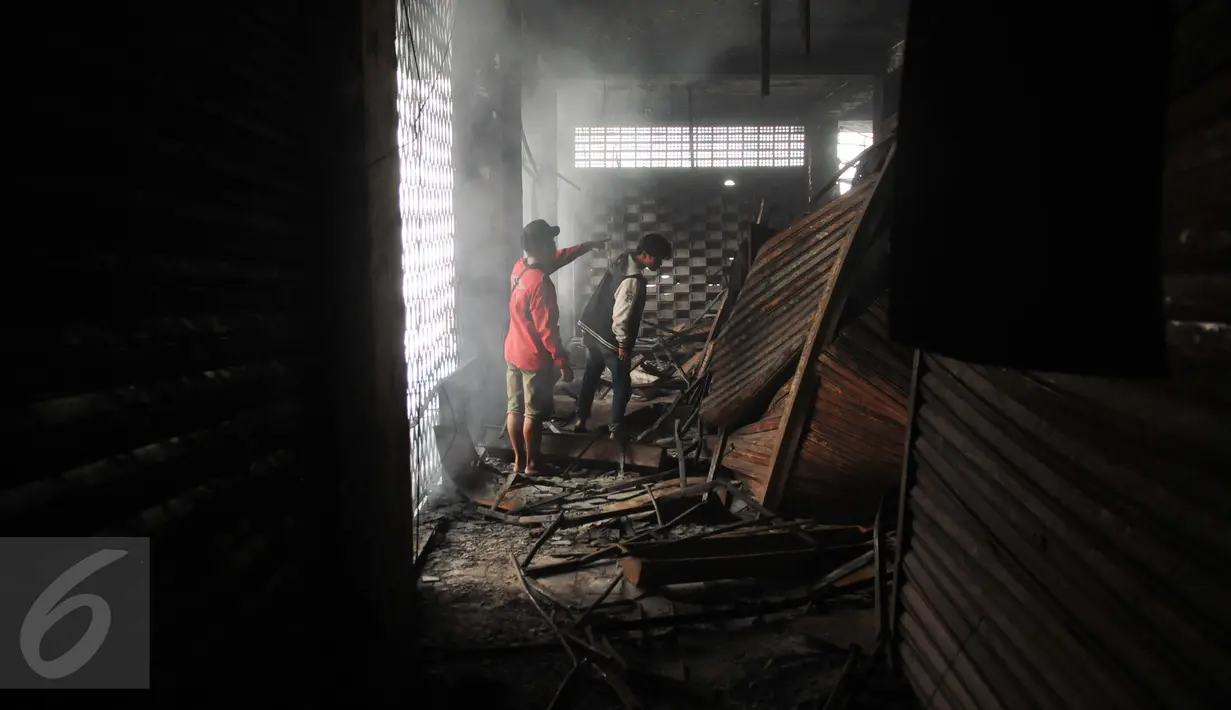 Warga mengecek sisa kios yang terbakar di Pasar Senen, Jakarta Pusat, Jumat (20/1). Pasar Senen sudah pernah dilanda kebakaran sebanyak enam kali. (Liputan6.com/Gempur M Surya)
