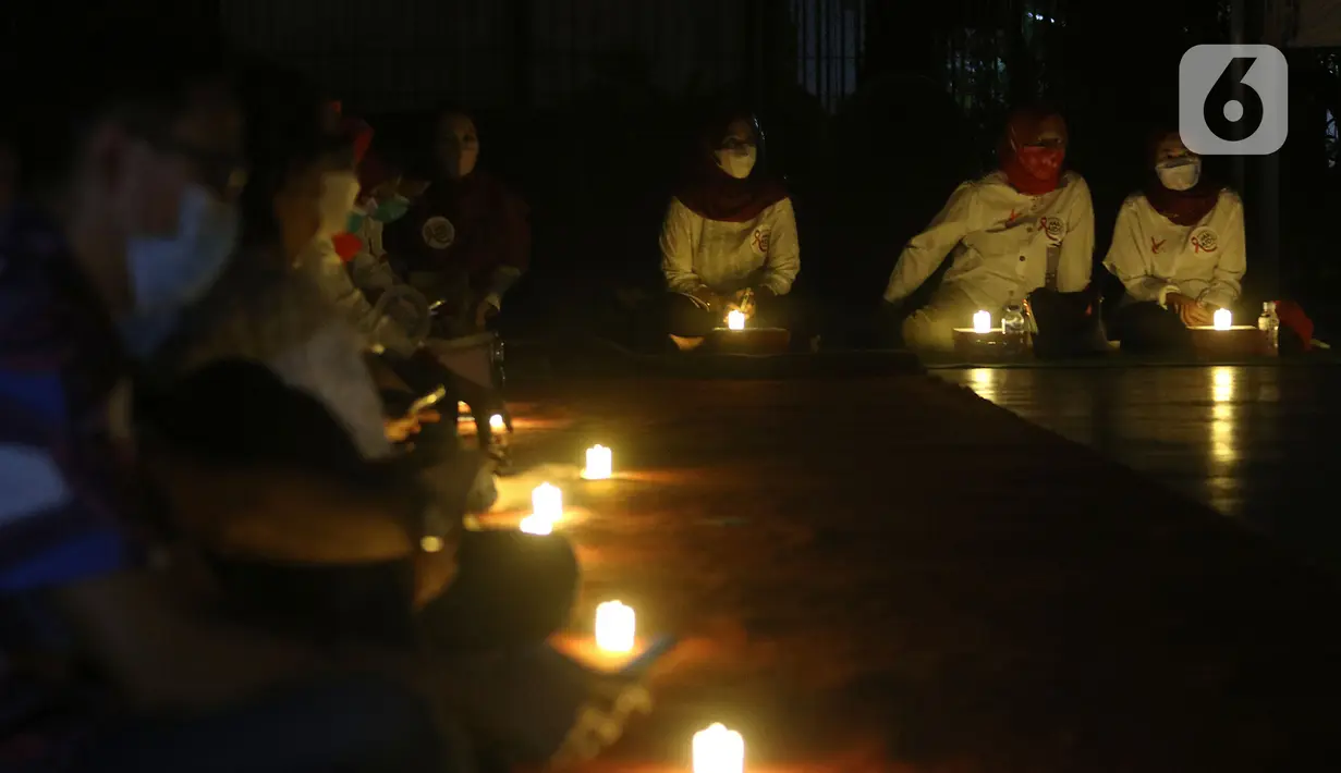 Sejumlah relawan menyalakan lampu pada malam renungan Hari AIDS Sedunia di Tanah Abang, Jakarta, Rabu (1/12/2021). Acara ini digelar secara gabungan oleh lembaga dan relawan pendamping orang dengan HIV/AIDS (ODHA). (Liputan6.com/Herman Zakharia)