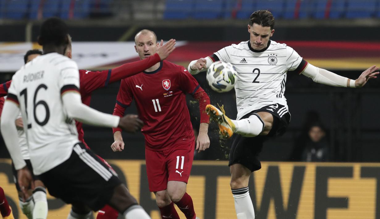Penyerang Republik Ceko, Michael Krmencik menyaksikan Robin Koch dari Jerman mencoba menembak bola dalam laga persahabatan di Red Bull Arena, Leipzig, Kamis (12/11/2020) dini hari WIB. Jerman sukses mengalahkan Republik Ceko dengan skor tipis 1-0. (AP Photo/Michael Sohn)