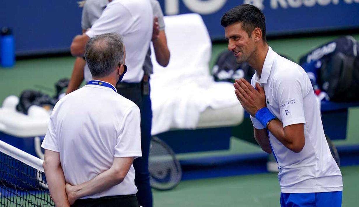 Petenis Serbia, Novak Djokovic, meminta maaf kepada wasit usai insiden bola mengenai hakim garis pada AS Terbuka, di Flushing Meadows, Senin (7/9/2020). Djokovic didiskualifikasi karena memukulkan bola tenis ke arah hakim garis. (AP/Seth Wenig)