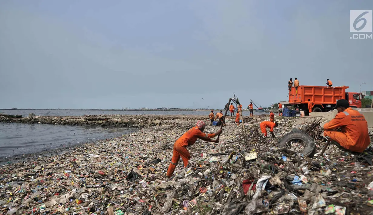 Petugas membersihkan sampah di pesisir Cilincing, Jakarta, Rabu (28/3). Menurut warga, hamparan sampah tersebut telah memenuhi pesisir Cilincing sejak puluhan tahun lalu hingga kini menjadi daratan yang dapat dilintasi. (Merdeka.com/Iqbal S. Nugroho)