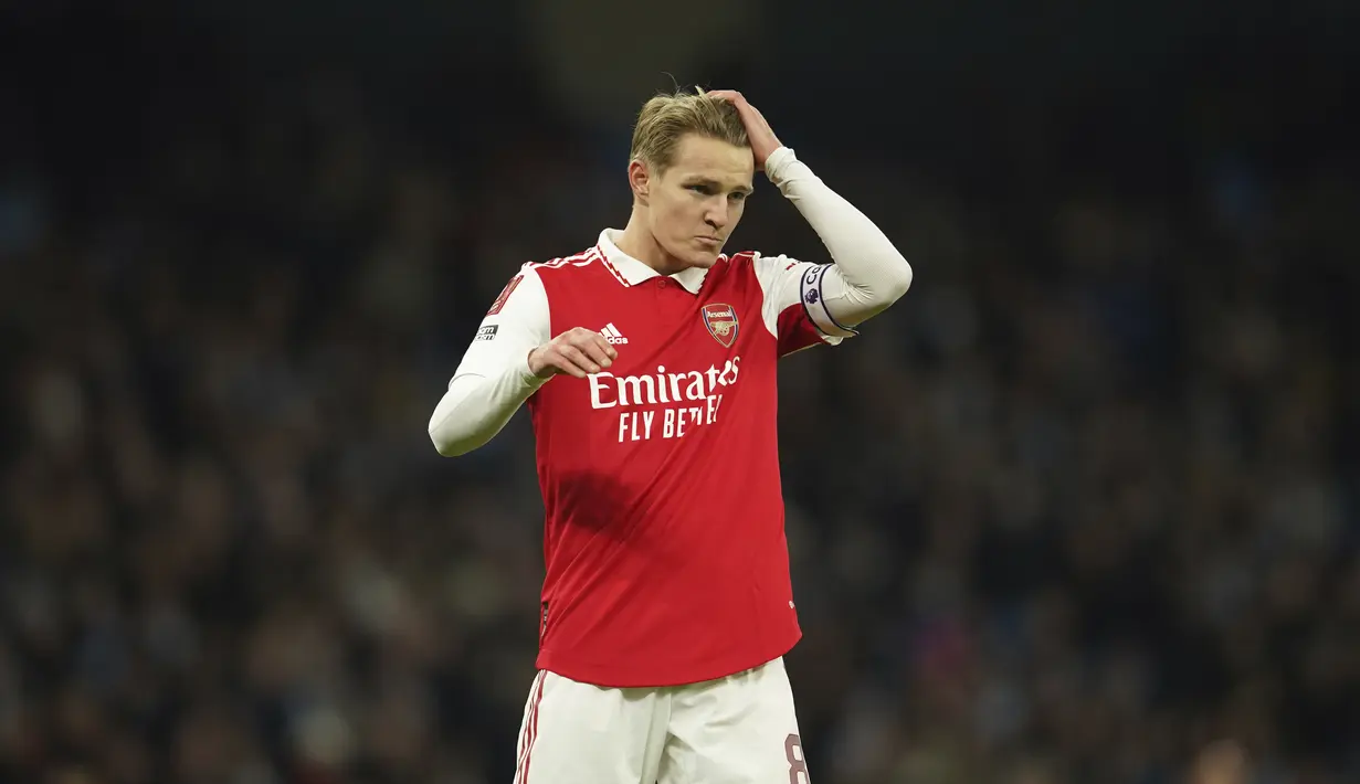 Reaksi Martin Odegaard dari Arsenal saat bertanding melawan Manchester City pada putaran keempat Piala FA di Stadion Etihad di Manchester, Inggris, Sabtu (28/1/2023). Kekalahan ini membuat Arsenal gagal lolos ke putaran kelima Piala FA 2022-2023. (AP Photo/Dave Thompson)