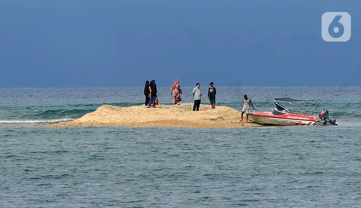 Wisatawan beraktivitas di pulau kecil kawasan Pantai Bama, Taman Nasional Baluran, Situbondo, Jawa Timur, Sabtu (29/4/2023). (merdeka.com/Arie Basuki)