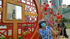 Warga berswafoto di depan ornamen dengan nuansa Imlek di kawasan Bundaran HI, Jakarta, Sabtu (29/1/2022). Ornamen yang didominasi warna merah dan emas ini dipasang dalam rangka menyambut perayaan Tahun Baru Imlek 2573, yang jatuh pada 1 Februari mendatang. (Liputan6.com/Herman Zakharia)