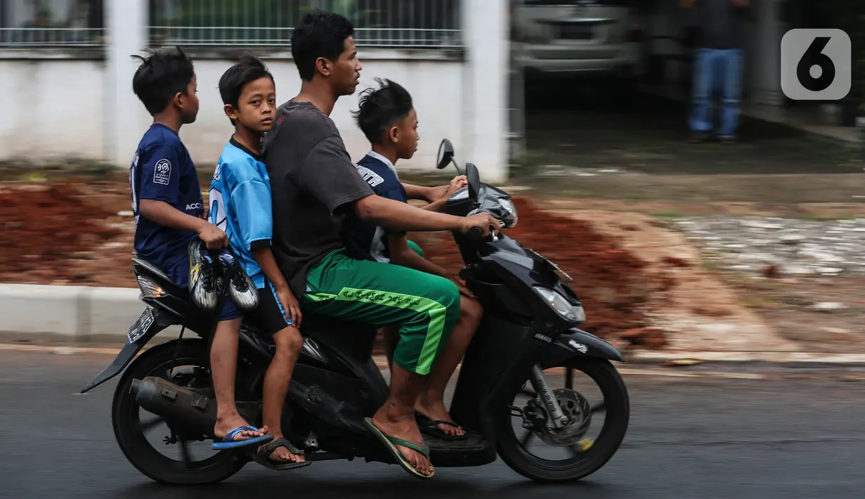Warga menggunakan sepeda motor melintasi jalan Bintaro Permai, Jakarta, Rabu (15/6/2022). Korps Lalu Lintas (Korlantas) Polri menghimbau kepada masyarakat khususnya pengguna motor untuk tidak menggunakan sandal dan celana pendek saat berkendara dikarenakan,sandal jepit tidak akan melindungi bagian kaki pengendara. (Liputan6.com/Johan Tallo)
