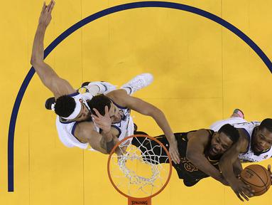 Aksi pemain Cavaliers, Tristan Thompson (2kiri) mencoba mencetak poin saat diadang para pemain Warriors pada gim pertama final NBA basketball di Oakland, California, (31/5/2018). Warriors menang 124-114. (Kyle Terada/Pool Photo via AP)