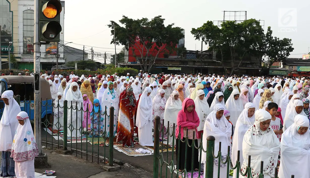 Umat muslim salat id Hari Raya Idul Fitri 1 Syawal 1439 H di kawasan Senen, Jakarta, Jumat (15/6). Setiap tahun, umat muslim antusias melaksanakan salat id dengan memadati jalan-jalan di sekitar stasiun dan pasar tersebut. (Liputan6.com/Immanuel Antonius)
