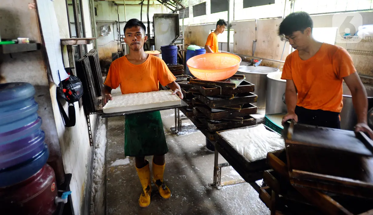 Pekerja menyelesaikan pembuatan tahu di Pabrik Tahu Krukut, Depok, Jawa Barat, Senin (31/10/2022). Kenaikan harga kedelai yang sekarang mencapai Rp 14 ribu/kg menyebabkan produksi tahu menurun dari 2,5 - 3 kwintal kedelai/hari kini hanya 2 kwintal/hari, sementara jumlah tenaga kerja pun harus dikurangi dari enam menjadi hanya lima orang. (merdeka.com/Arie Basuki)