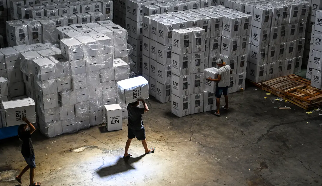 Pekerja menata kotak suara yang berisi surat suara sebelum dimasukkan ke dalam truk untuk didistribusikan ke kecamatan-kecamatan di gudang Komisi Pemilihan Umum (KPU) di Surabaya pada 5 Februari 2024. (Juni KRISWANTO/AFP)