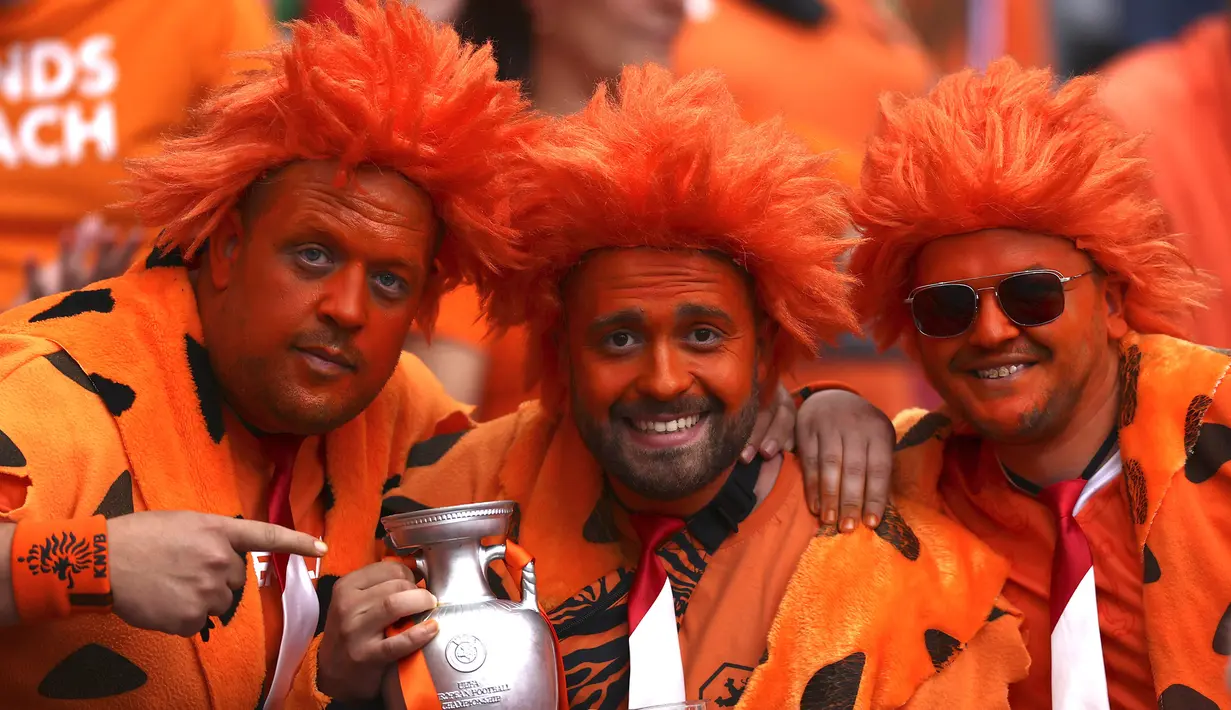 Suporter Belanda bersorak sambil menggenggam replika trofi Euro sebelum dimulainya pertandingan grup C kejuaraan sepak bola Euro 2020 antara Belanda dan Austria di Johan Cruyff ArenA, Amsterdam, Belanda, Kamis, 17 Juni 2021. (Foto: AP/Pool/Dean Mouhtaropoulous)