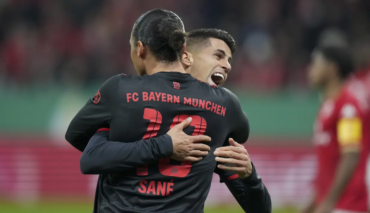 Bek Bayern Muenchen, Joao Cancelo berselebrasi setelah rekannya Leroy Sane mencetak gol ke gawang Mainz 05 selama pertandingan babak 16 besar Piala Jerman (DFB Pokal) di Mewa Arena, Mainz, Jerman (1/2/2023). Pemain pinjaman dari Manchester City membuktikan kualitasnya sebagai salah satu fullback terbaik di daratan Eropa saat ini. (AP Photo /Michael Probst)