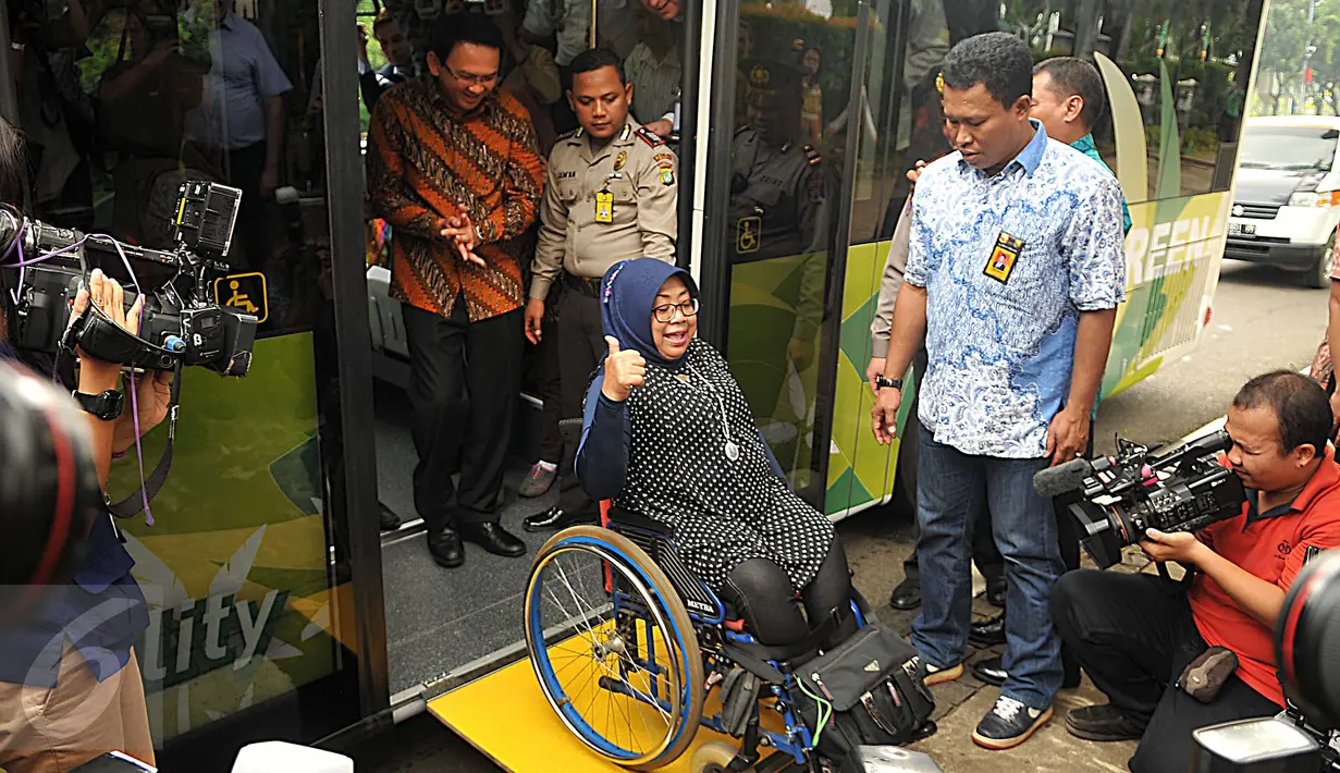 Gubernur DKI Basuki 'Ahok' Tjahaja Purnama melihat seorang penyandang disabilitas turun dari bus Scania jenis premium Low City Bus usai test drive display bus di Balai Kota DKI Jakarta, Jumat (11/3). (Liputan6.com/Gempur M Surya)